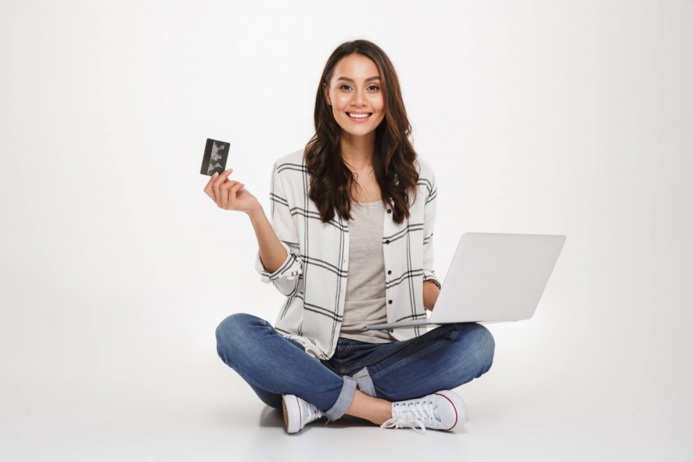 Une femme souriante qui a trouvé une solution pour améliorer sa cote de crédit rapidement en ligne