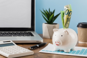 Mise en avant d'une tirelire avec une calculatrice afin de calculer son épargne